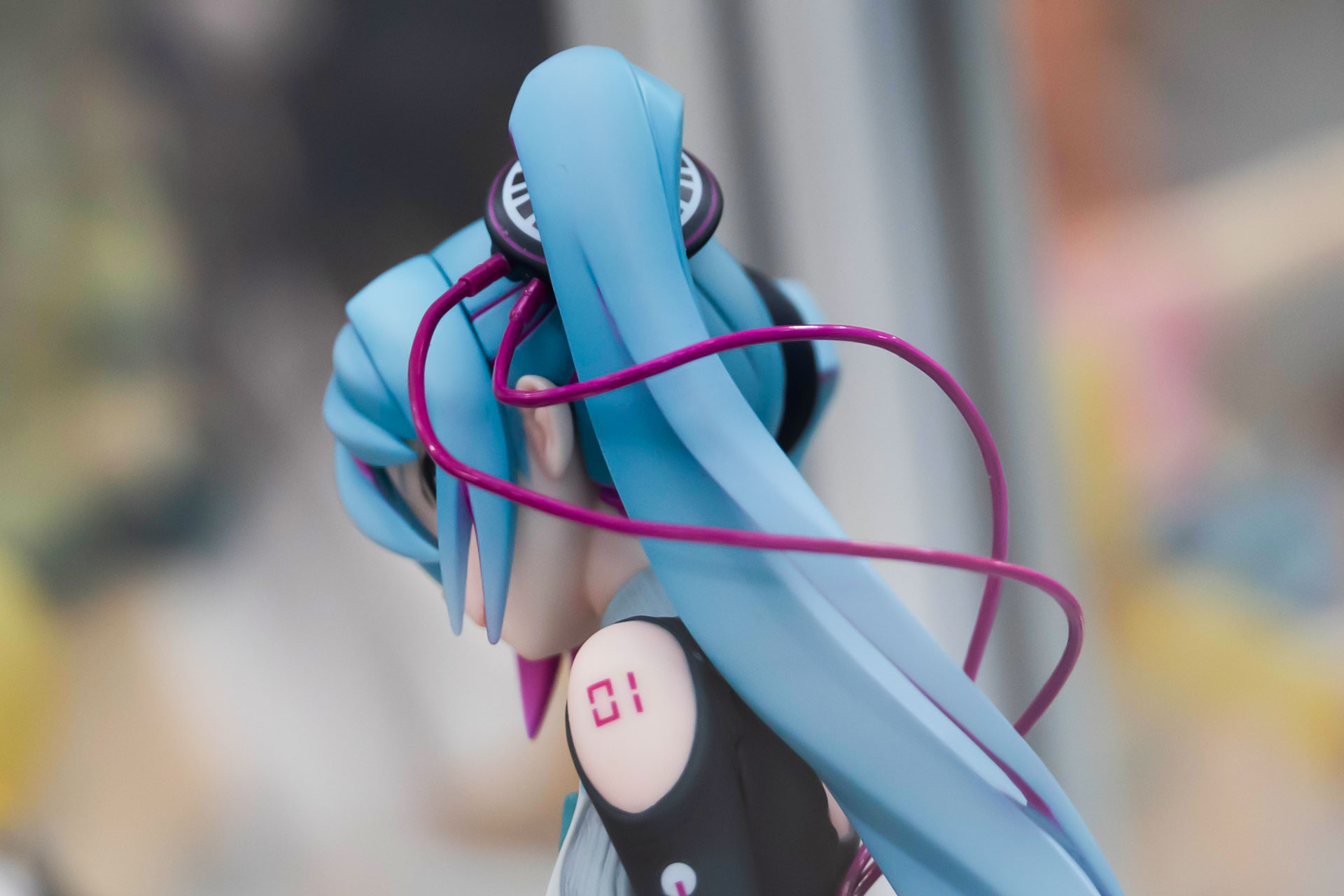 ツインテールをまとめているアクセサリーからは、長いコードが伸びている