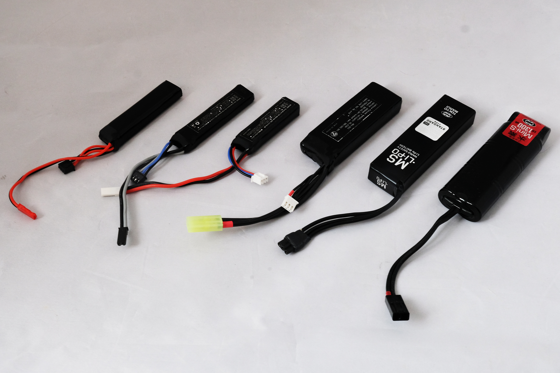 左から4つめまでが既存の玩具用リポバッテリー。ケーブルの色やコネクターの形状までバラバラだ