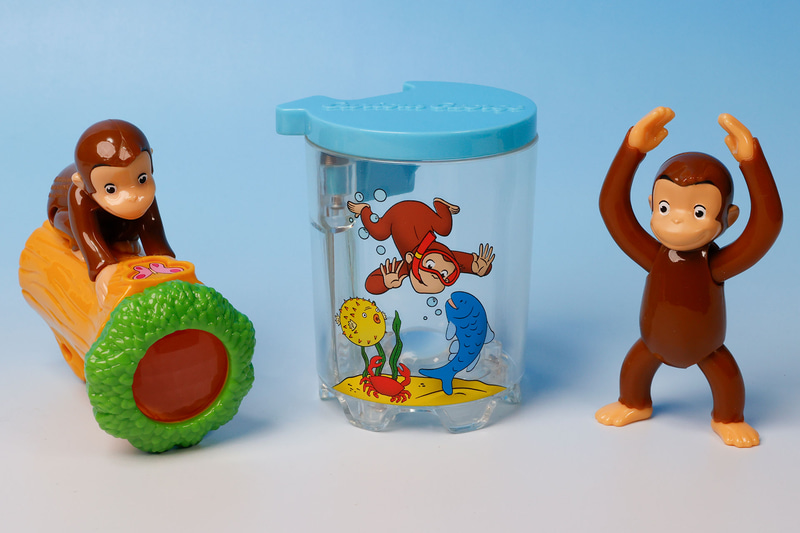 こちらが第2弾（1月19日～1月25日）のハッピーセット「おさるのジョージ」に登場するおもちゃ。写真左から「ジョージのふしぎスコープ」、「ジョージの水でびっくり虫めがね」、「ジョージのはさんでキャッチ」