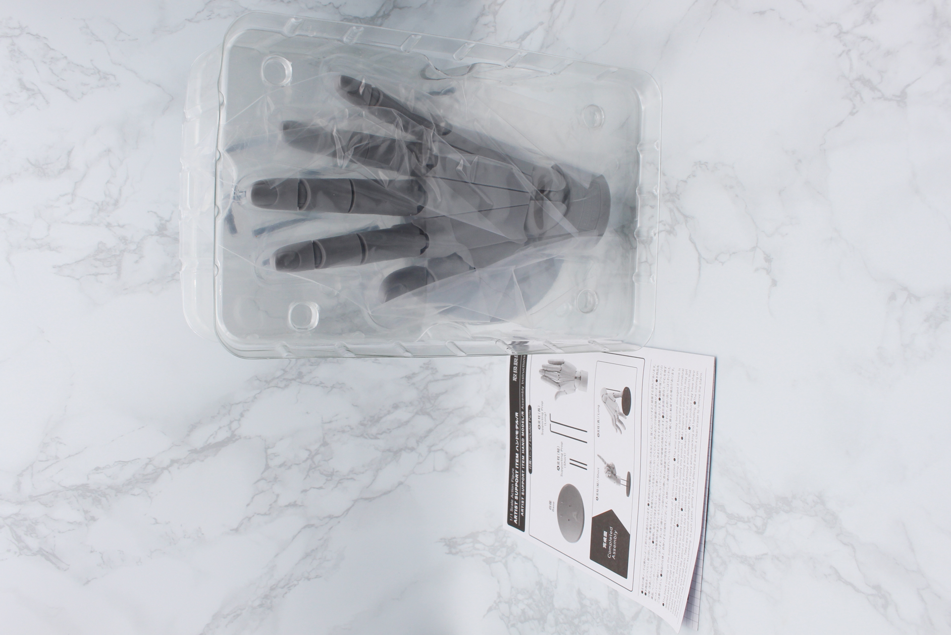 ブリスターは2枚重ねで、下には台座と支柱が入っている。説明書には使い方とともに、加々美氏によるハンドモデルを使った手の描き方のポイント解説も