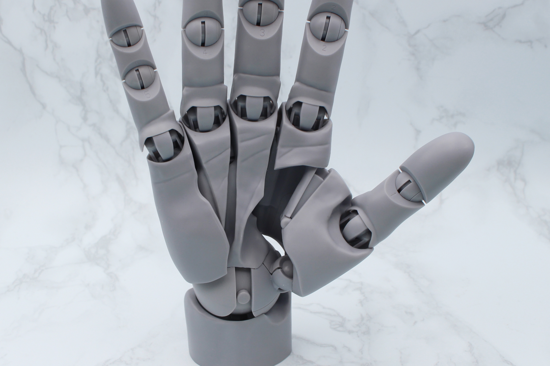 親指の付け根は伸縮するように可動。付け根にある扇形に10mmほど開くスライド関節にも注目