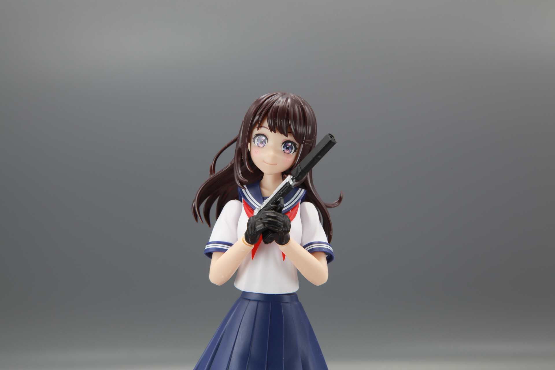 胸の前でハンドガンを両手で持ち上げるポーズ