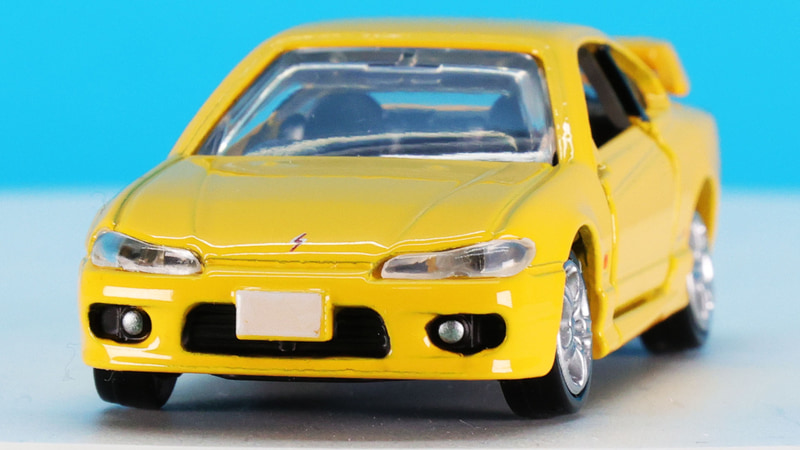 ロー&ワイドなボディを強調させる細めで釣り目なヘッドライトはクリアーパーツで実現