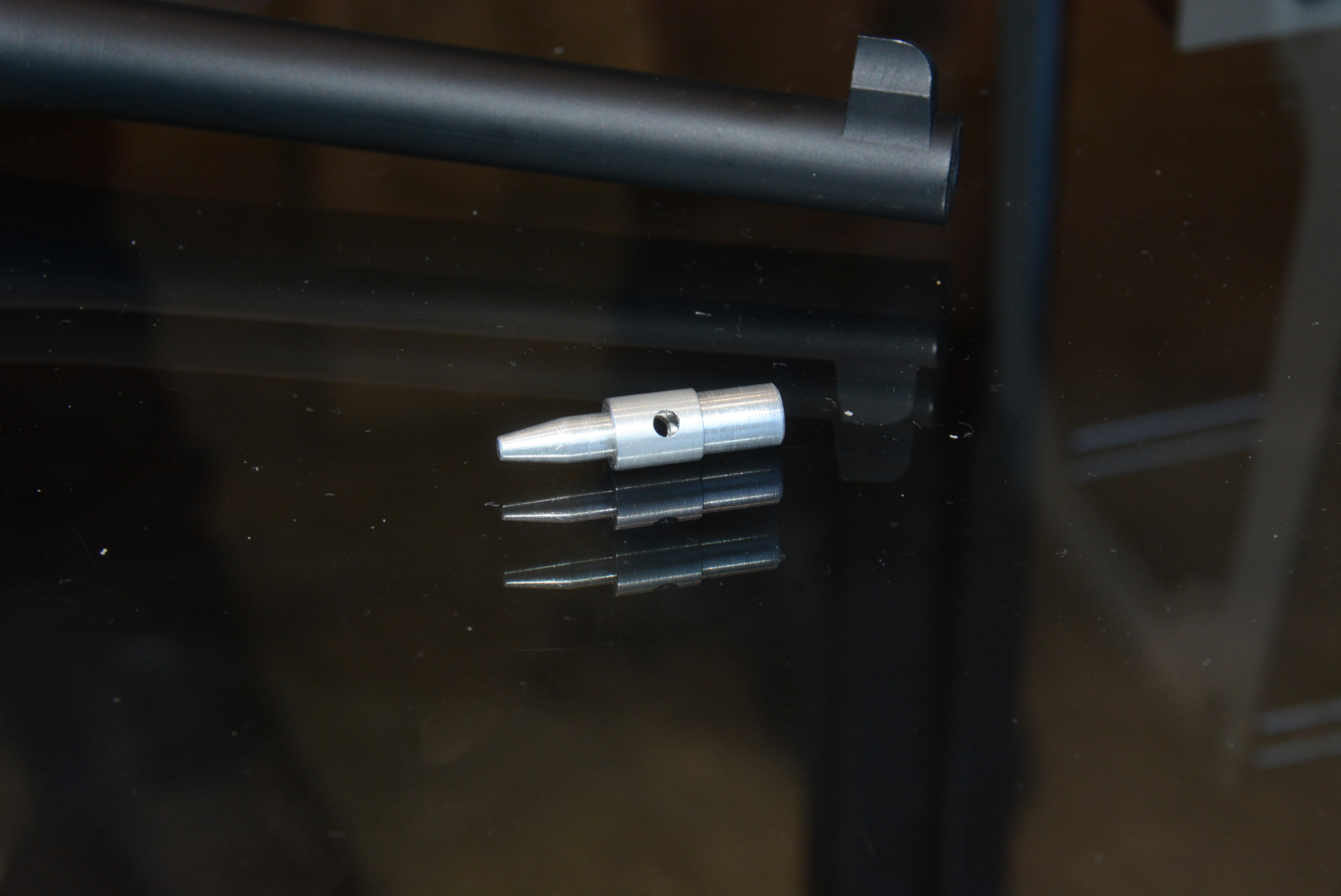 カートリッジの中に先端部分が差し込まれ、ボルトがカートリッジをこのデトネーターに激しく押しつけることで発火が行われる。写真の部品は横にしか穴が開いていないが、製品版は上下にも穴が開いており、より効率的な「ガス抜け」が行われる