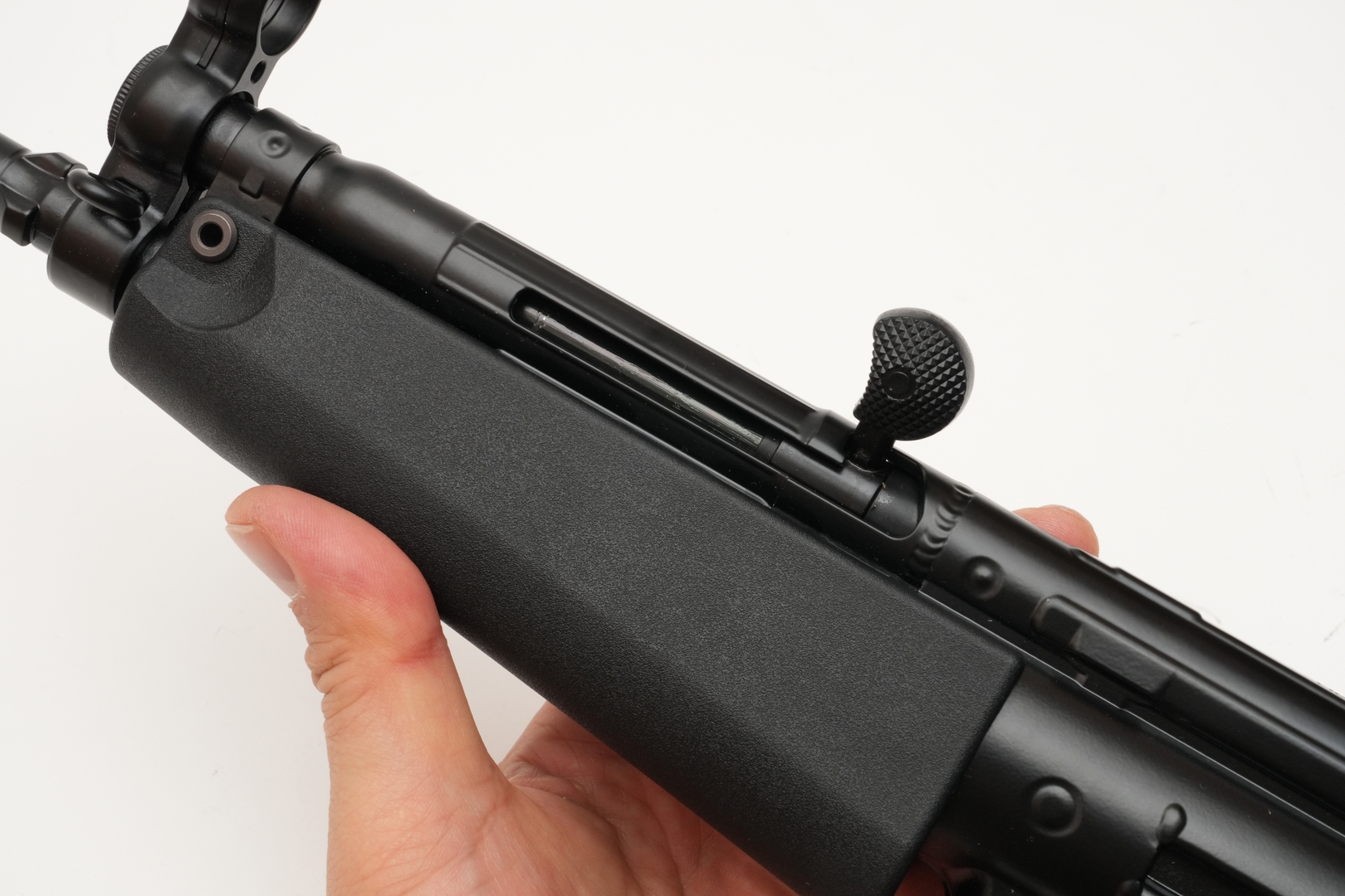 コッキングレバーを引いてロックする。この後、ホップ調整ダイヤルを回す際には、レバーに触れて、エジェクションポートが閉まらないように注意しよう