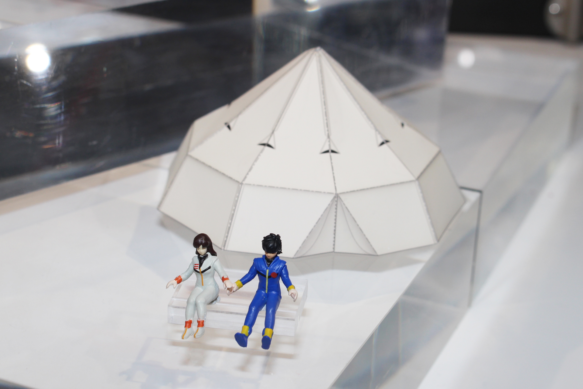 パラシュートを改造して作ったテントは型紙をコピーして作るペーパークラフト。手前にあるのは輝と未沙のフィギュア
