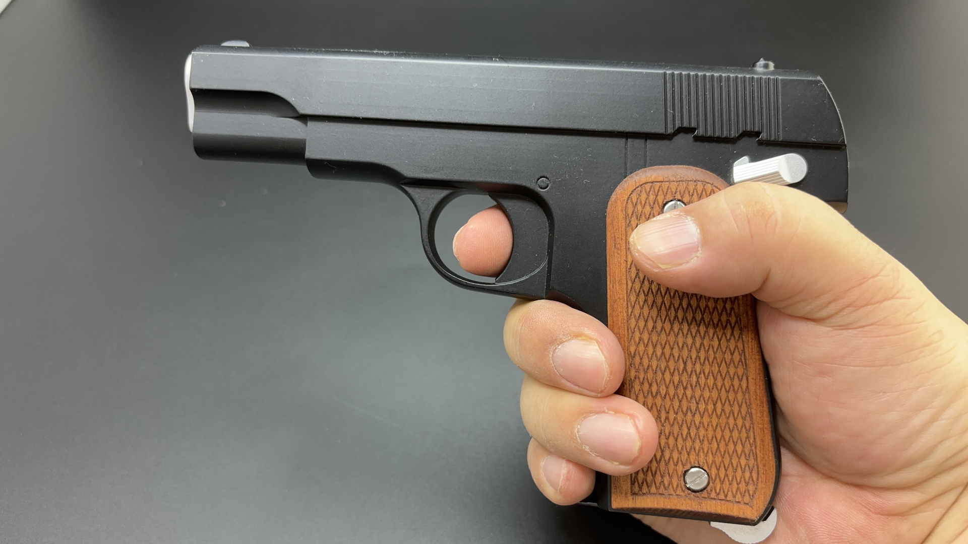 杉浦式自動拳銃は、実銃が削り出しで作られているからモチーフに選ばれた。筆者の手でもスライド底部の金具が小指にひっかかる。かなり小型の拳銃だというのが握って実感できる