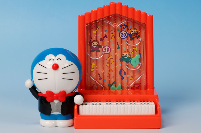 燕尾服を着たドラえもんが、オルガンの横に立っている姿が再現されている