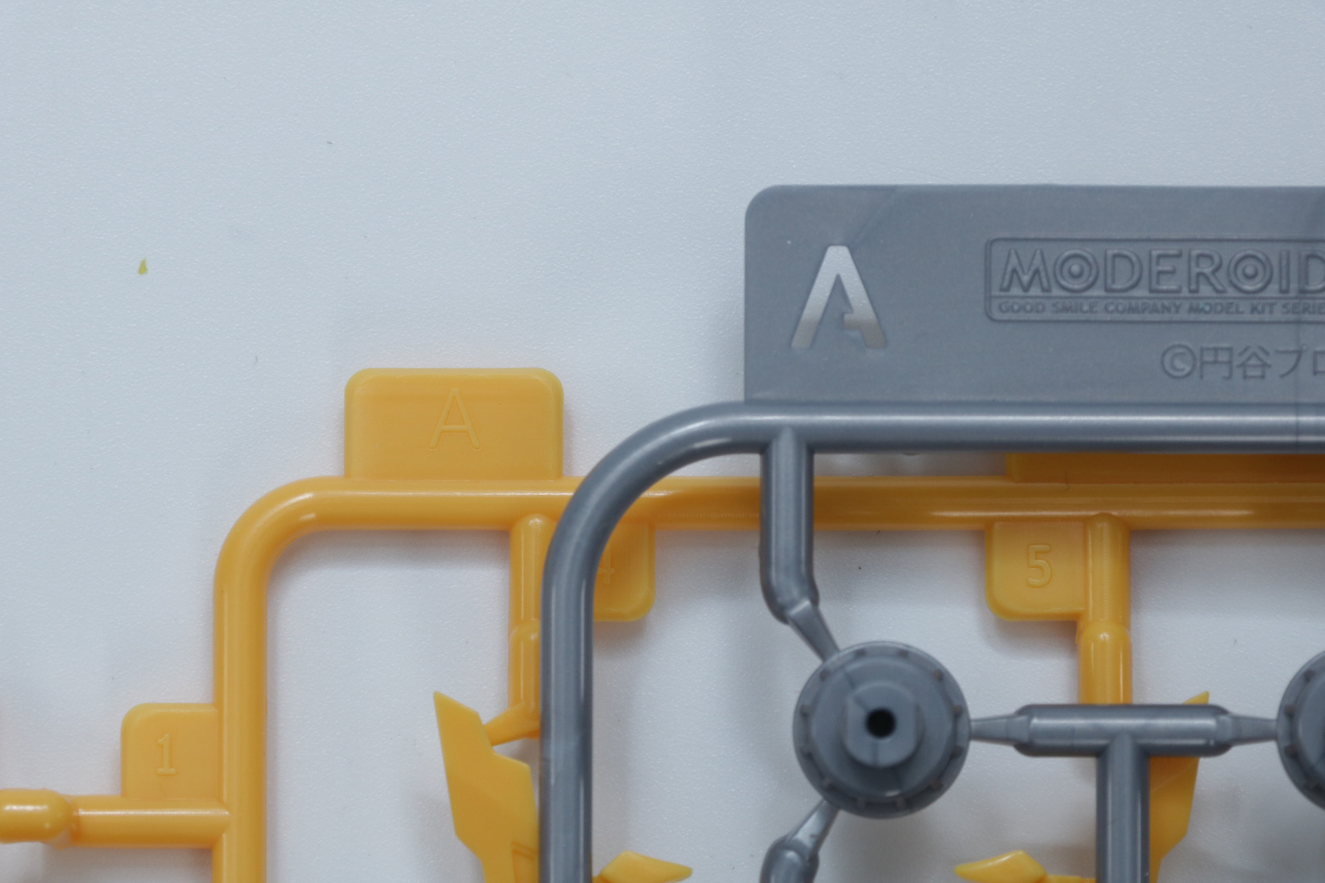 「MODEROID グリッドマン (Universe Fighter)&ビッグゴルドバーン」（手前）と「MODEROID ダイナゼノン」（奥）のランナー表記比較