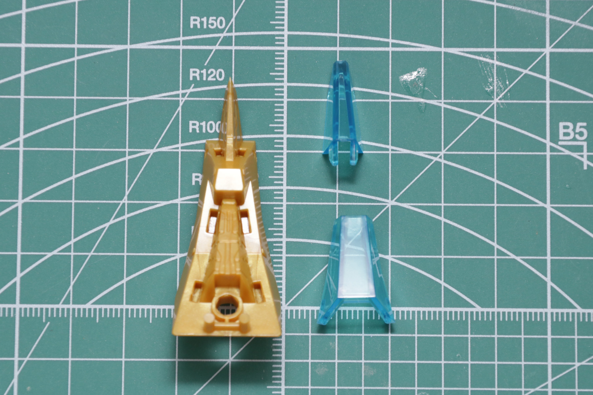 胸飾り下部のエンブレム部分。ホイルシールを貼り、クリアパーツを被せて組み立て