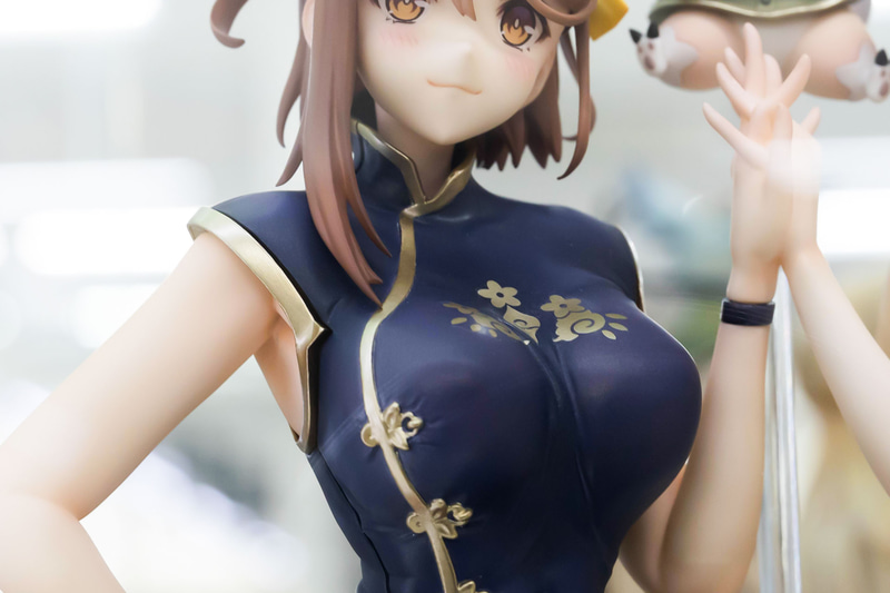 ライザが身に付けているチャイナドレスは、紺色に金の装飾がほどかされている