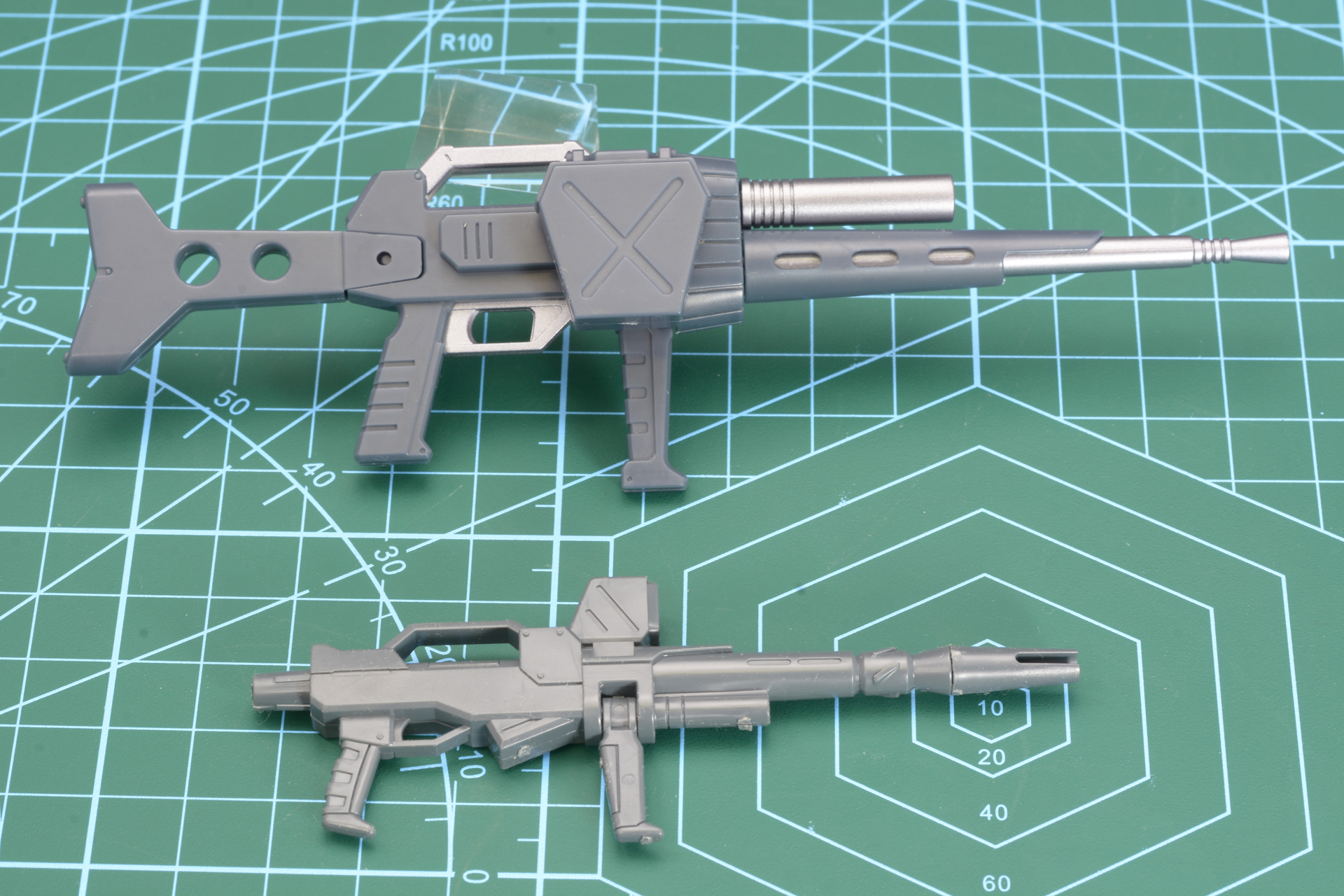 ドムのバズーカなどはあったものの、主武装の大きさとしては当時のアニメではかなり異質な存在と言える「ヘビィマシンガン」(画面上)。下は比較のために並べた「MG 陸戦型ガンダム」などに付属するビーム・ライフル