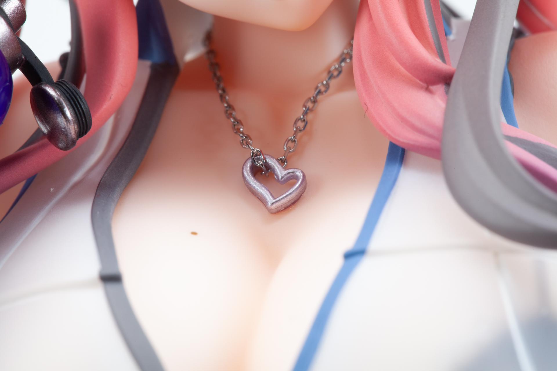 胸元にはハートの形をした銀色のネックレスが表現