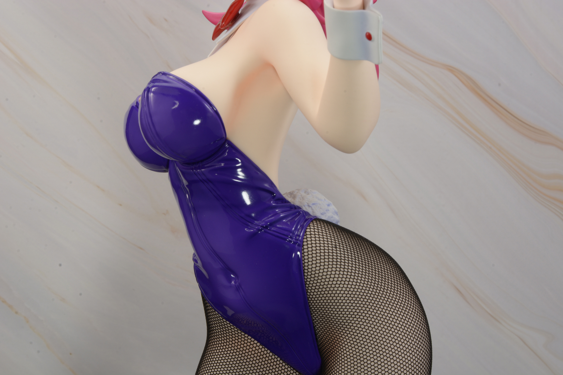 女の子の体を包む、光沢を放つエナメルのボディスーツ