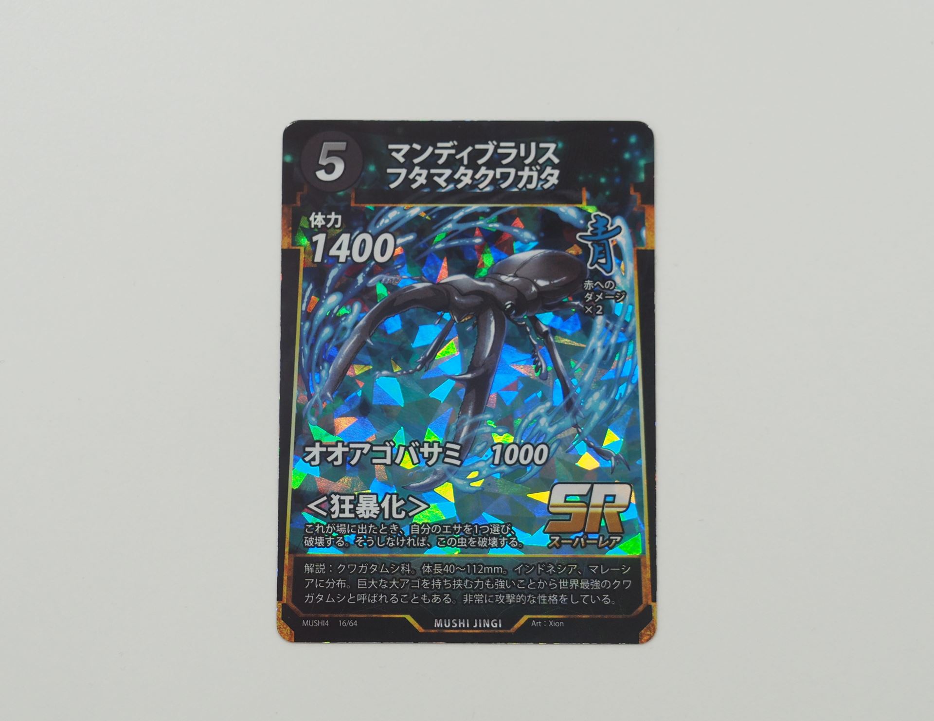 青5コストのSRカード「マンディブラリスフタマタクワガタ」。先行体験会で初出のカード。場に出たとき、自分のエサを1つ選び破壊する。そうしない場合はこの虫を破壊する＜狂暴化＞を持つ