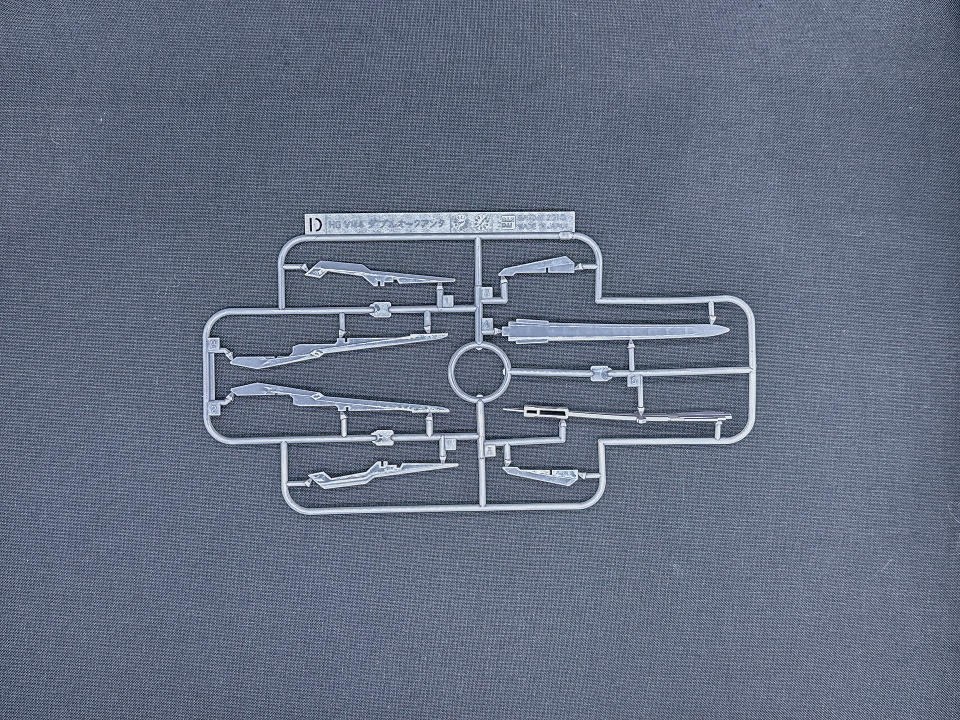 「HG 1/144 ガンダムダブルオーコマンドクアンタ・デザートタイプ」を構成するランナー。グレーのランナーはビームサーベルエフェクトパーツと同様に軟質樹脂による成型となっています。