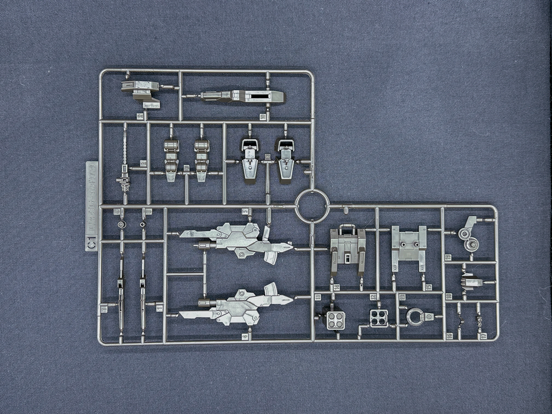 「HG 1/144 ガンダムダブルオーコマンドクアンタ・デザートタイプ」を構成するランナー。グレーのランナーはビームサーベルエフェクトパーツと同様に軟質樹脂による成型となっています。