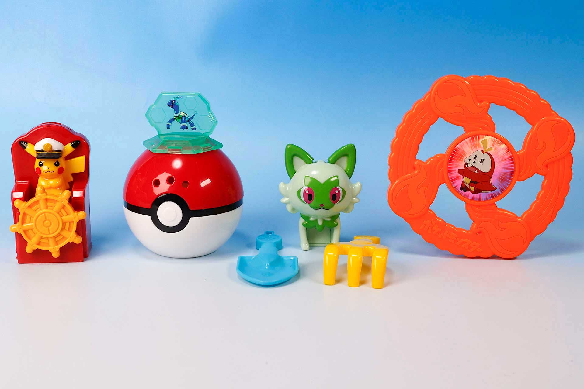 こちらが第1弾（8月9日〜8月15日）のハッピーセット「ポケモン」に登場するおもちゃ。写真左上から「キャプテンピカチュウのくるくる水車」、「テラパゴスのモンスターボールじょうろ」、「ニャオハのツールキット」、「ホゲータのフライングディスク」