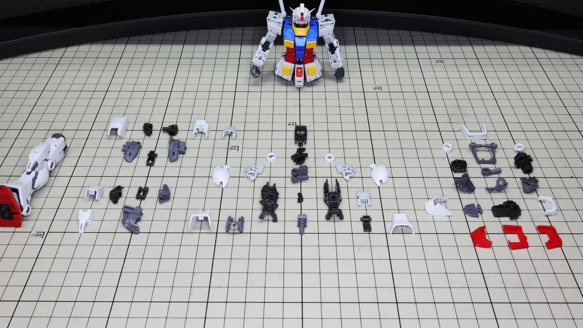 構成要素の多い脚部のパーツ群。左上が大腿部、左下が膝アーマー、中央が脛下部、右がソールです。既に右脚を組んでいます