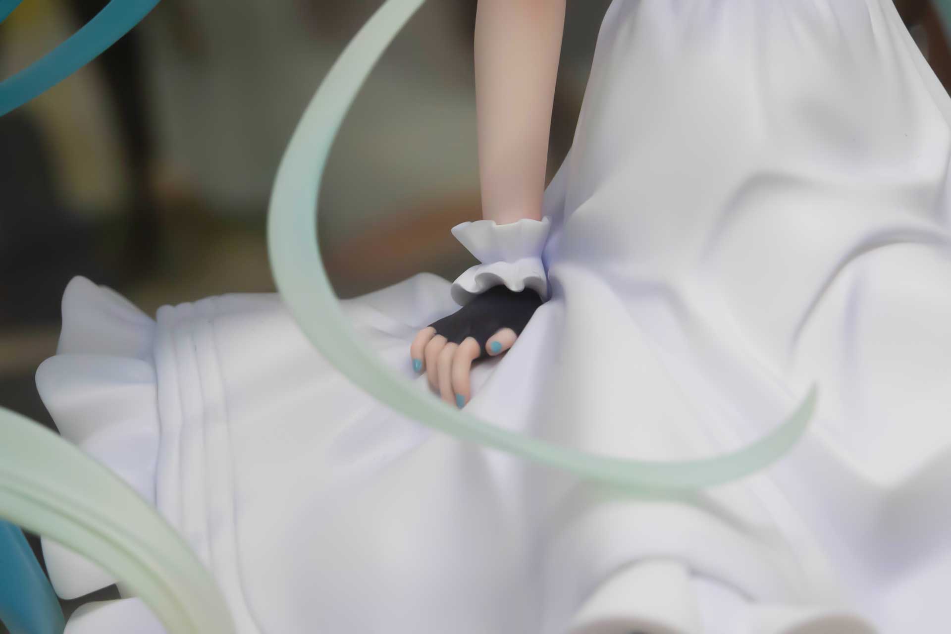 手の指は青いネイルが塗られている