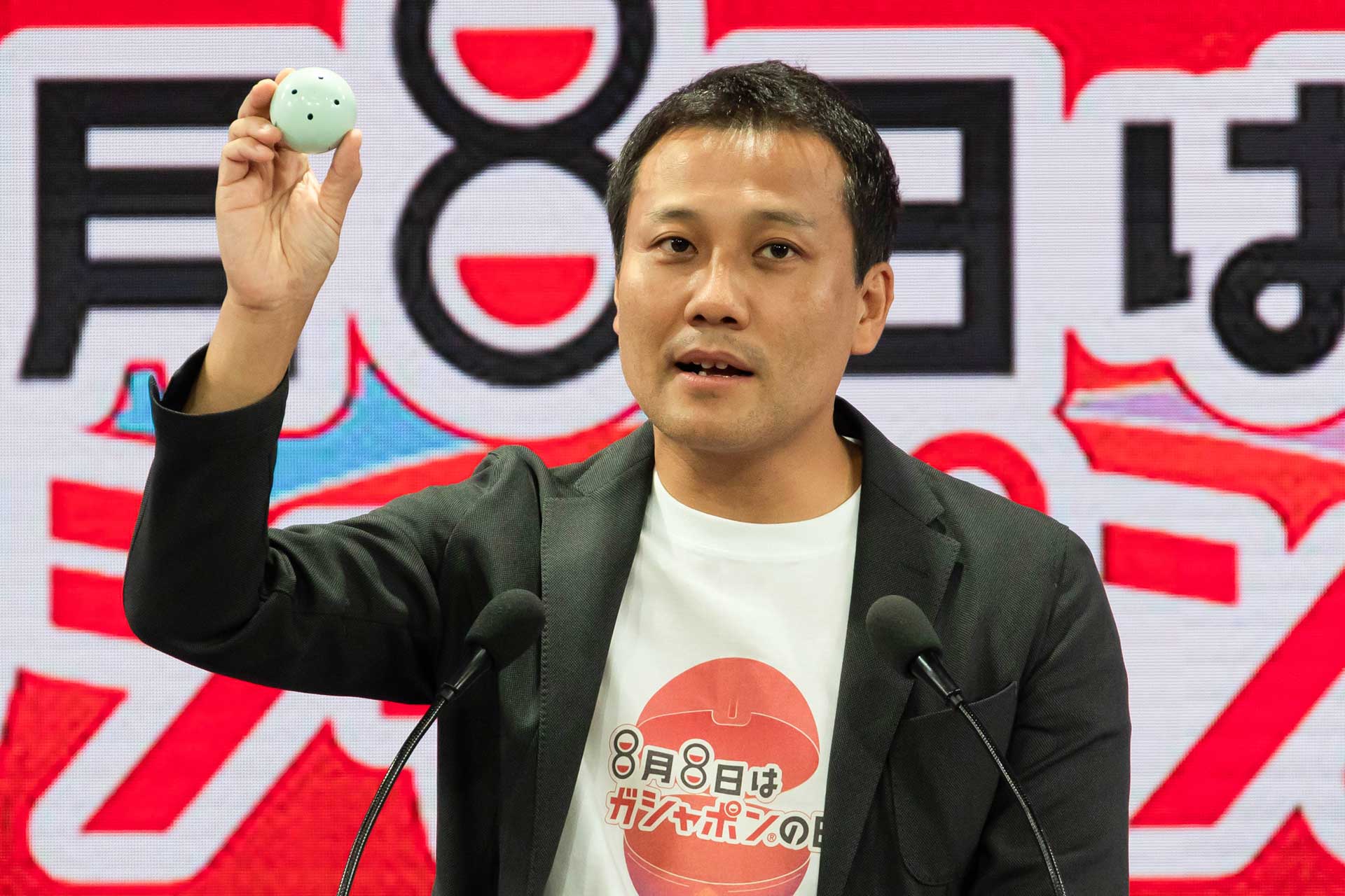 滝口氏が手に持っているのがエコ素材を活用した「グリーンカプセル」だ