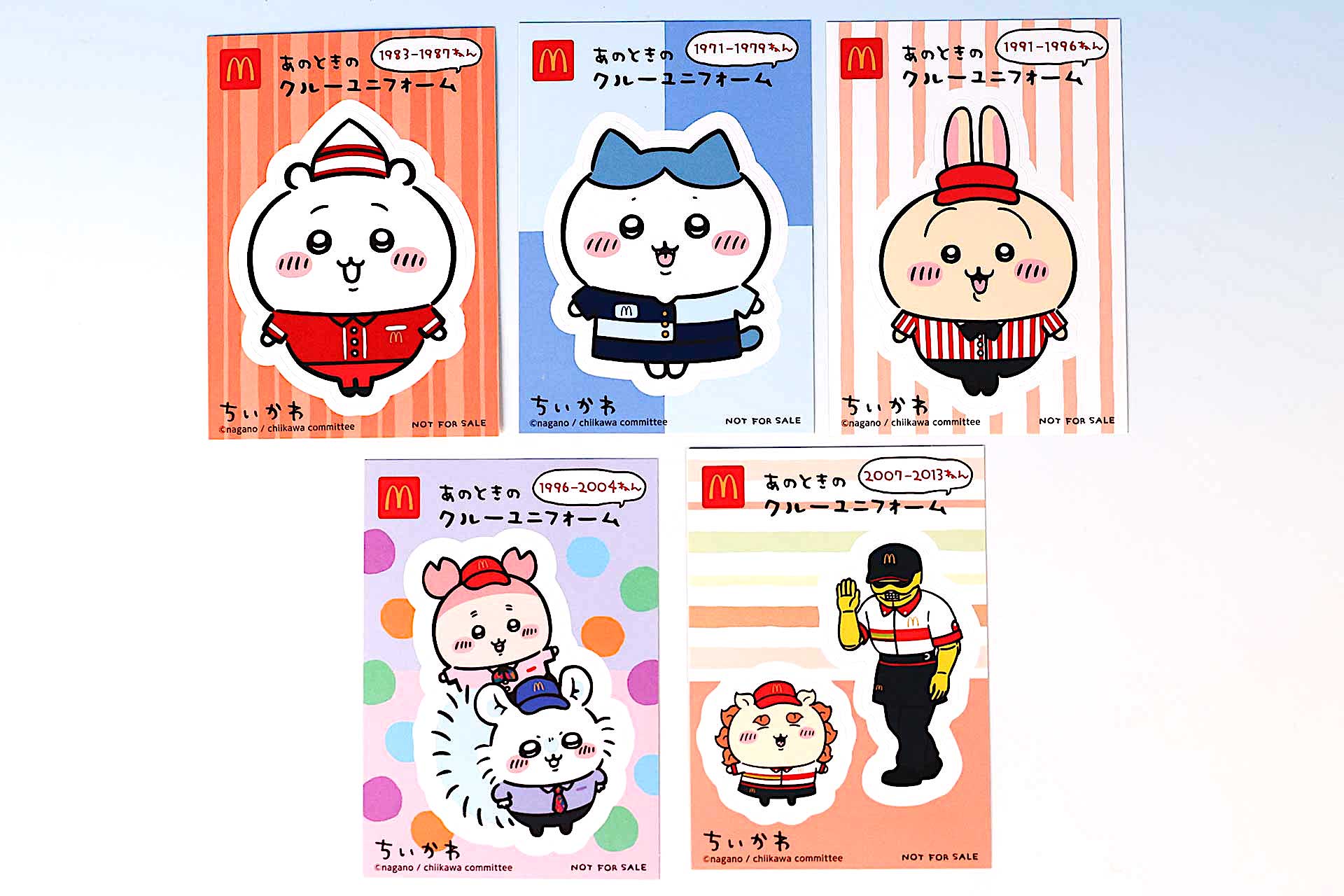 こちらが今回のハッピーセット「ちいかわ」（8月30日〜）に登場するおもちゃだ。写真左上から「ちいかわ 1983-1987年 クルーユニフォーム」、「ハチワレ 1971-1979年 クルーユニフォーム」、「うさぎ 1991-1996年 クルーユニフォーム」。左下から「モモンガ＆カニ(古本屋) 1996-2004年 クルーユニフォーム」、「シーサー＆ラーメンの鎧さん 2007-2013年 クルーユニフォーム」