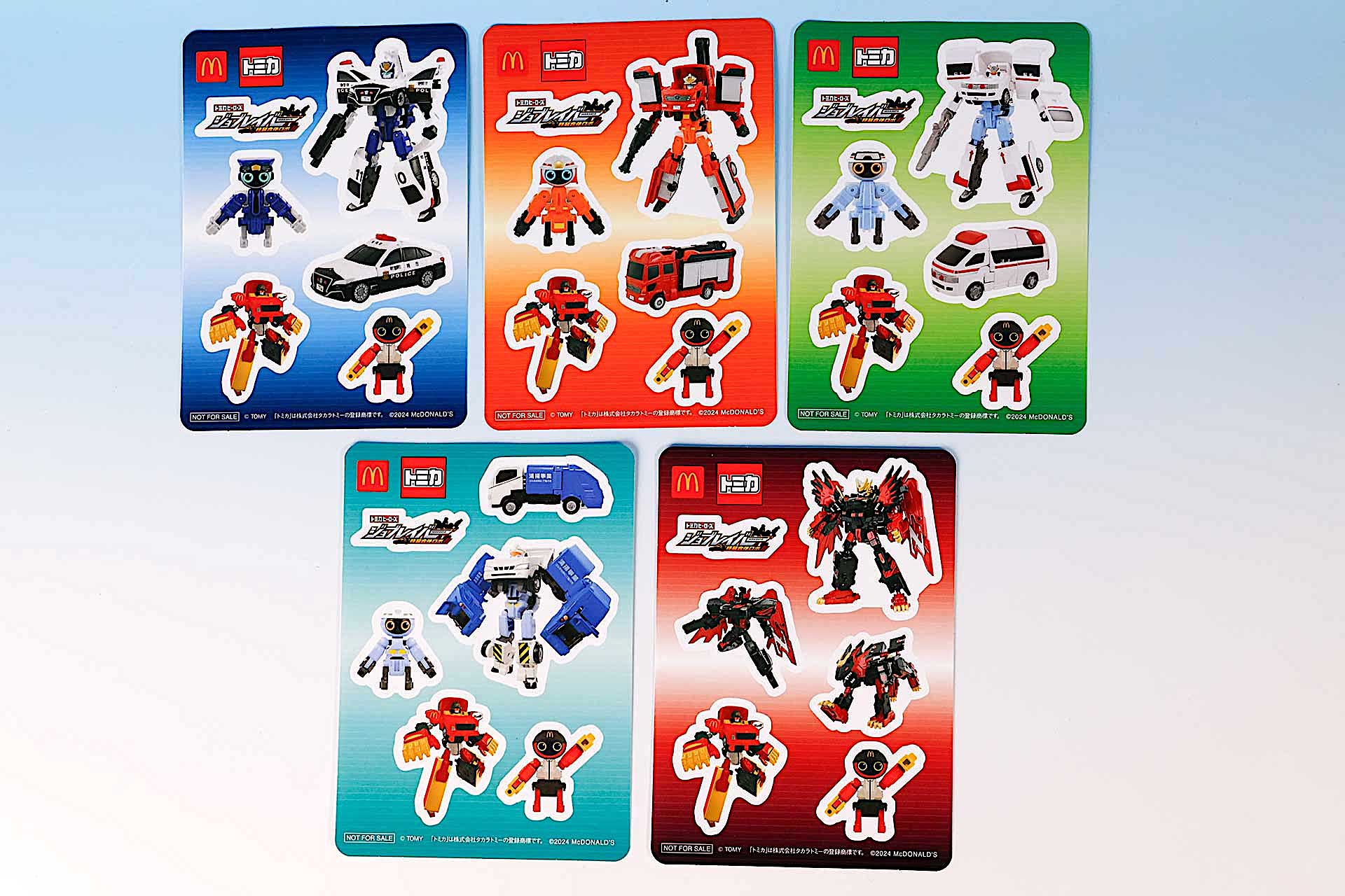 こちらが今回のハッピーセット「トミカヒーローズ ジョブレイバー」（8月30日〜）に登場するおもちゃだ。写真左上から「ポリスブレイバー トヨタ クラウン パトロールカー」、「ファイヤブレイバー モリタ 多目的消防ポンプ自動車 MVF」、「メディブレイバー トヨタ ハイメディック救急車」。左下から「クリーンブレイバー トヨタ ダイナ 清掃車」