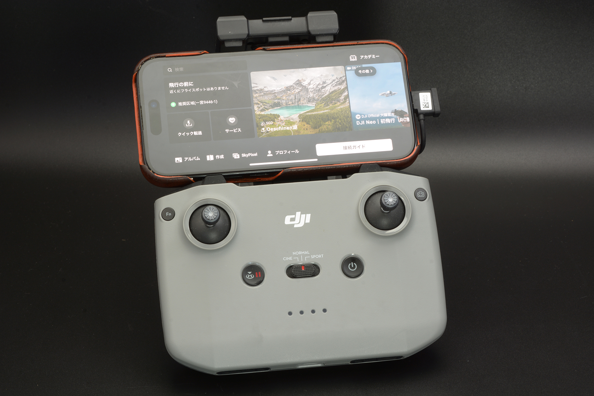 操縦アプリ「DJI Fly」をインストールしたスマホを送信機に接続して操作を行う
