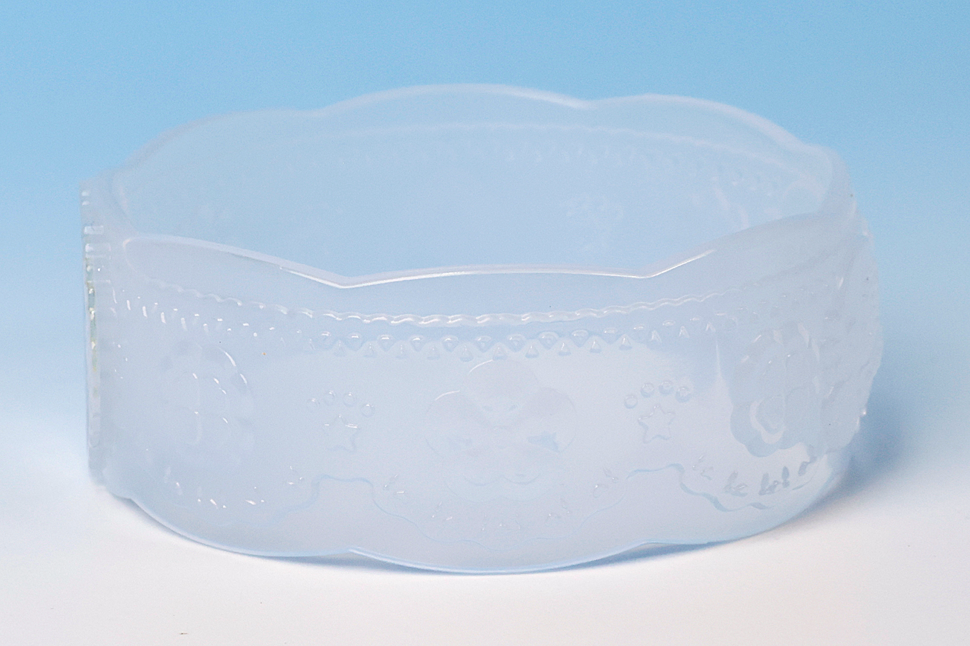 白いブレスレットには花をモチーフにしたデザインが散りばめられている