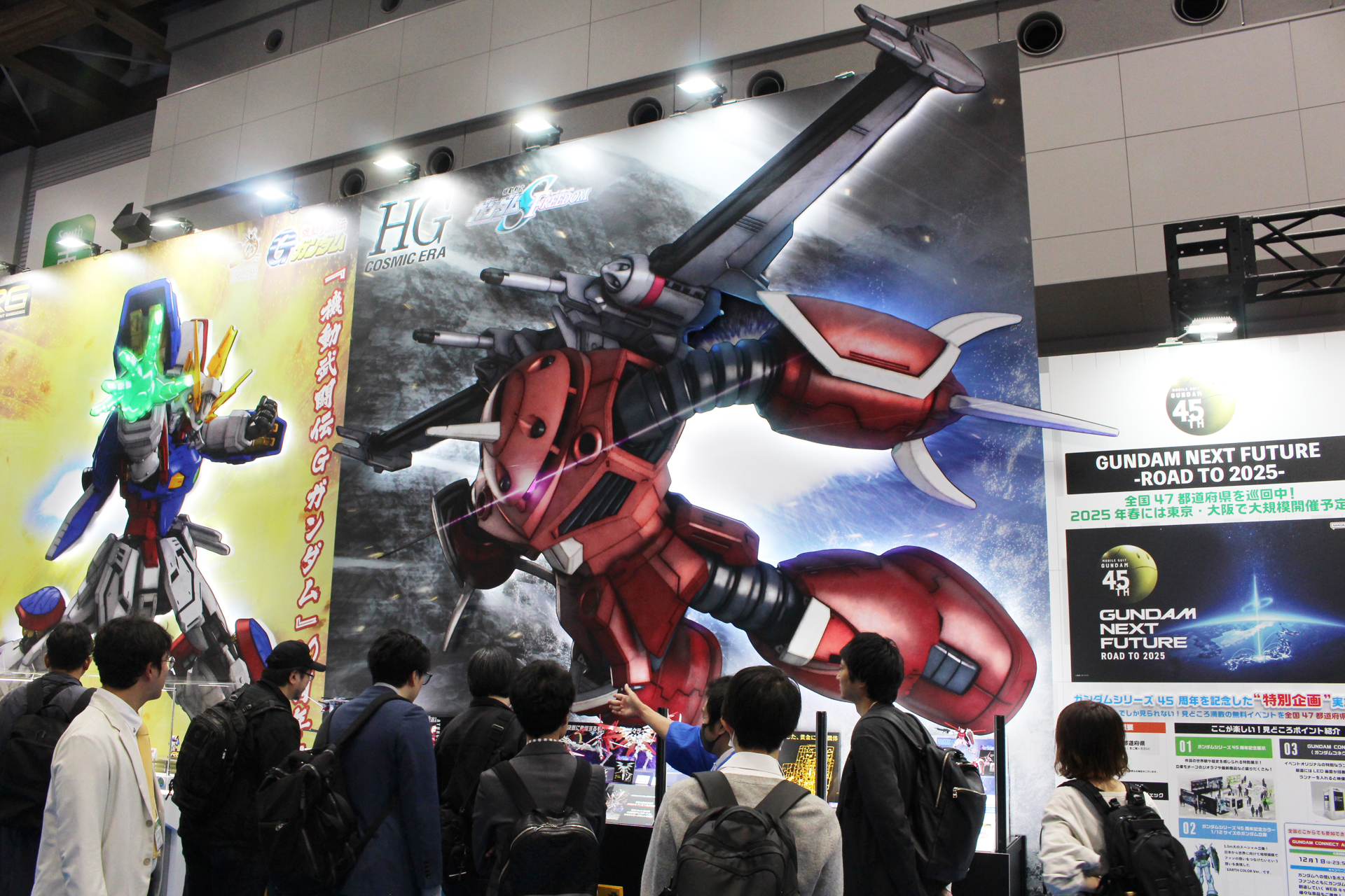 BANDAI SPIRITSブースの「HG 1/144 ズゴック（SEED FREEDOM Ver.）」展示コーナー。巨大なパネルが用意され、新発表の「RG 1/144 シャイニングガンダム」の隣に展示された
