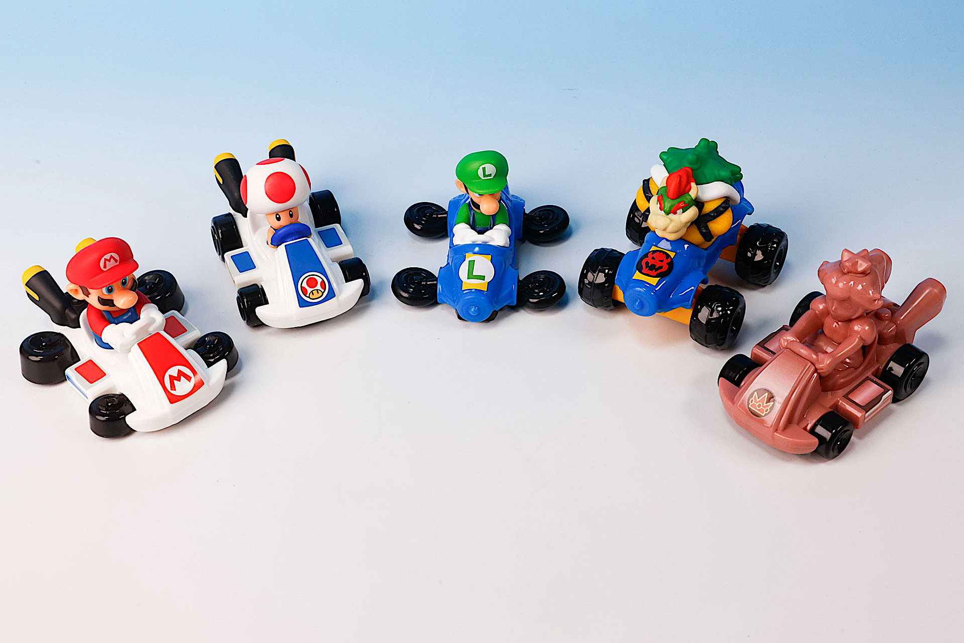こちらが第1弾（11月15日〜11月21日）のハッピーセット「マリオカート」に登場するおもちゃ。写真左から「マリオ」、「ピノキオ」、「ルイージ」、「クッパ」、「ピンクゴールドピーチ」