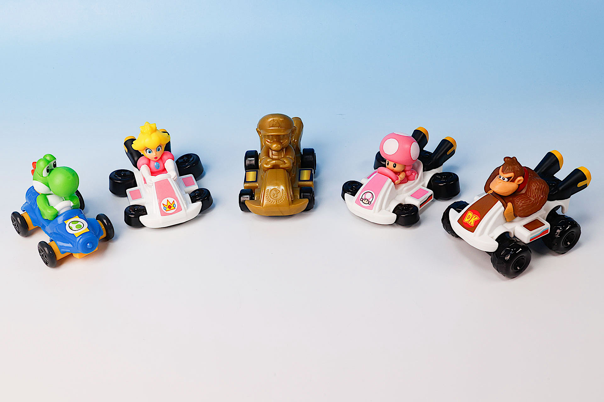 こちらが第2弾（11月22日〜11月28日）のハッピーセット「マリオカート」に登場するおもちゃ。写真左から「ヨッシー」、「ピーチ」、「ゴールドマリオ」、「キノピコ」、「ドンキーコング」
