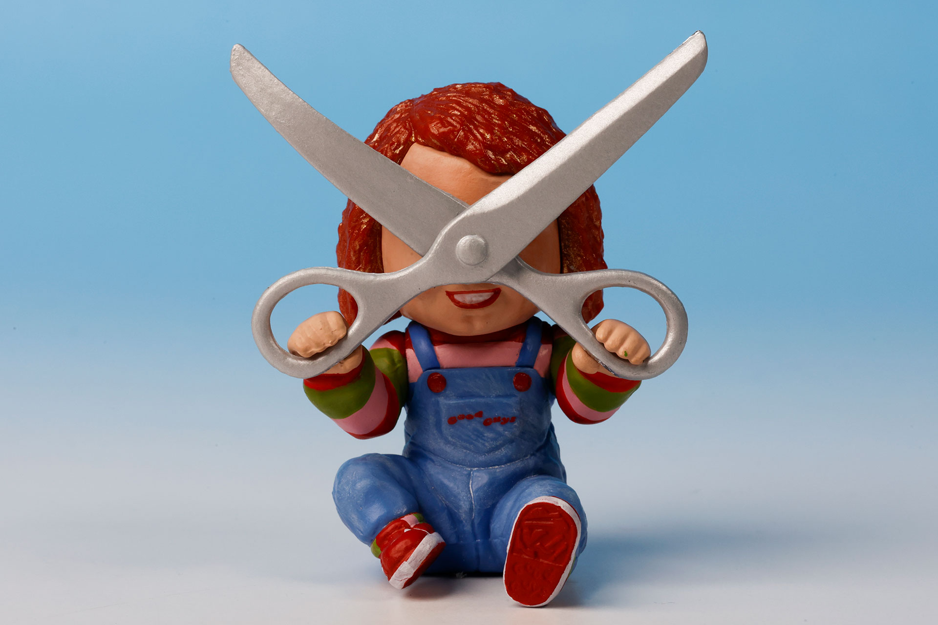 手に持ったハサミで顔を隠しているチャッキー