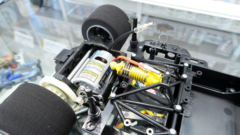 ギヤケースを搭載したFRP製Tバーの動きをCVAオイルダンパーで制御するリジッドタイプのリヤサスペンション