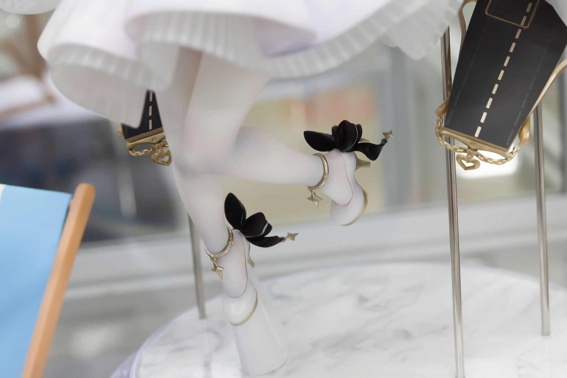 足元のハイヒールには大きめの黒いリボンが付けられている