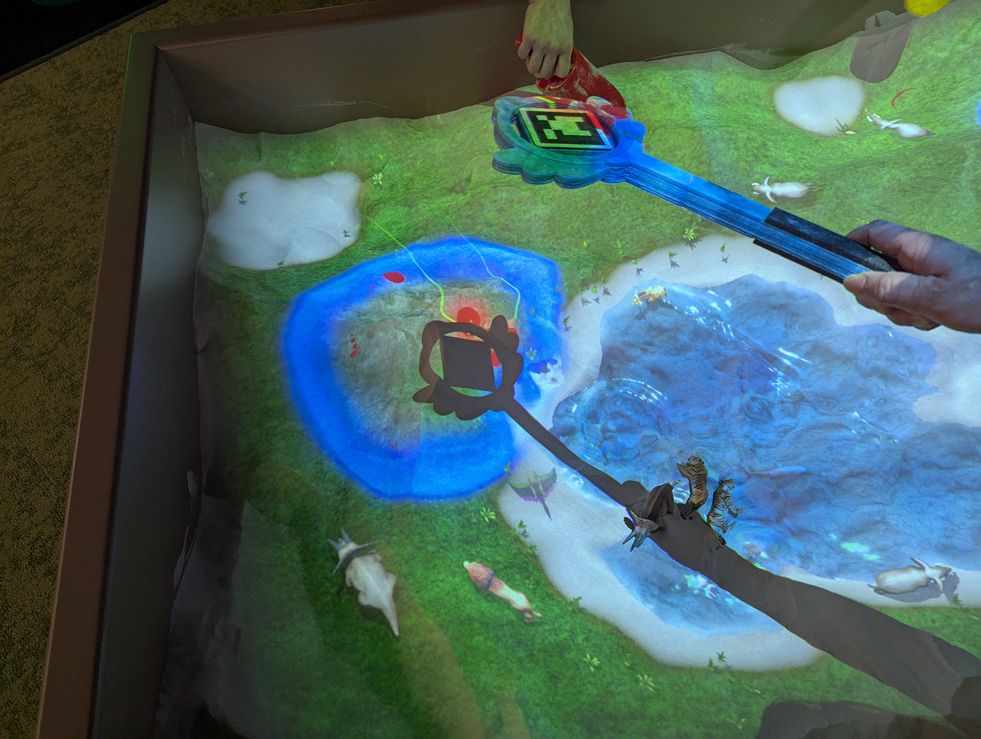 魔法のステッキを砂場にかざすことで掘るべきポイントが赤くマークされる