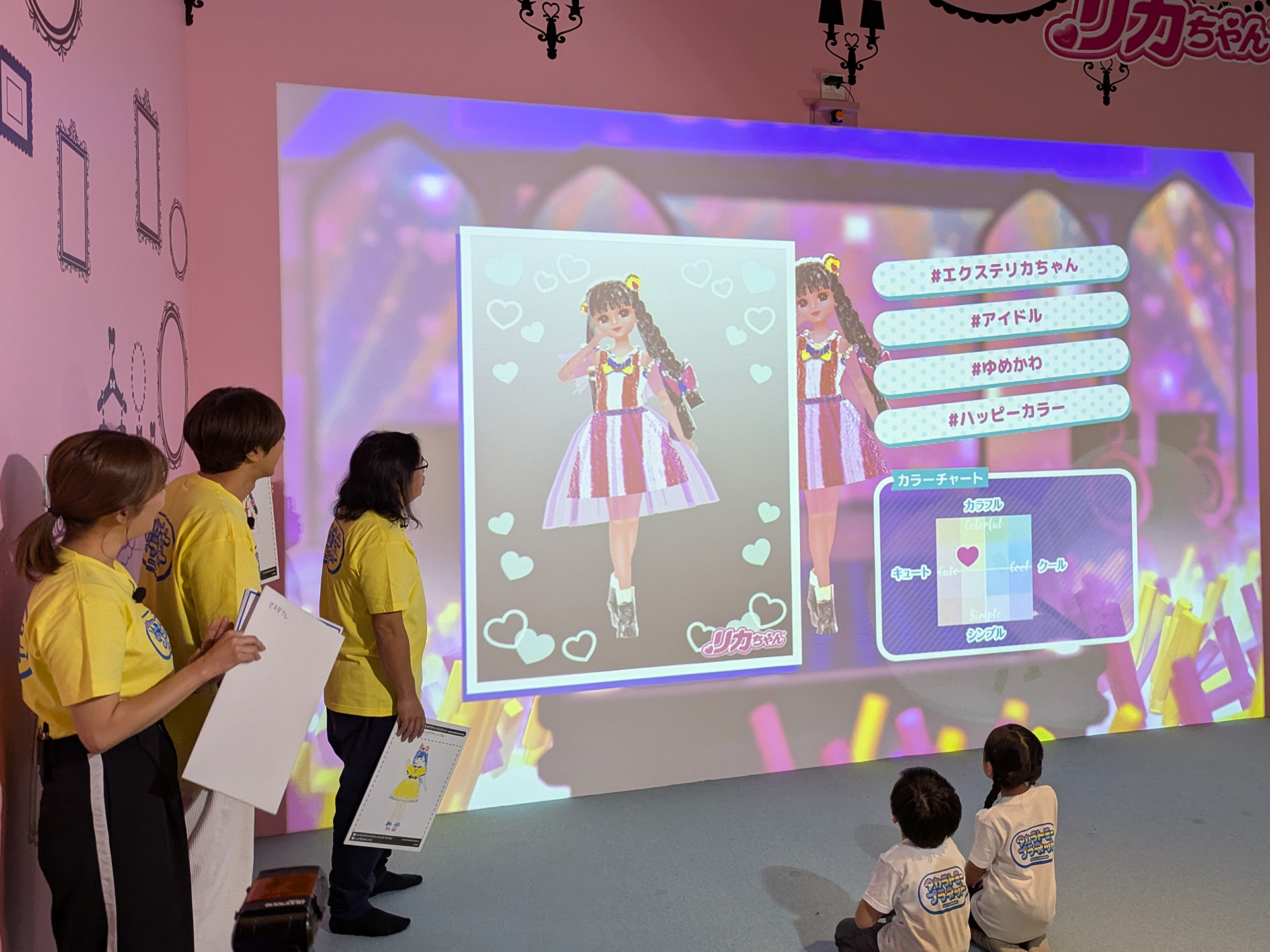 「リカちゃん おえかきデザインコレクション」ではMCの舛田氏も加わり3人のデザインのどれが1番気に入るかを子供たちに選択してもらった。画像はコカド氏デザインの服となるが、実際に趣味で服を作っているだけあって、かなり気合いが入ったデザインだ。ただし子供たちの高評価は得られず、なんでやねんと悲しみの声をあげて会場の笑いを誘った