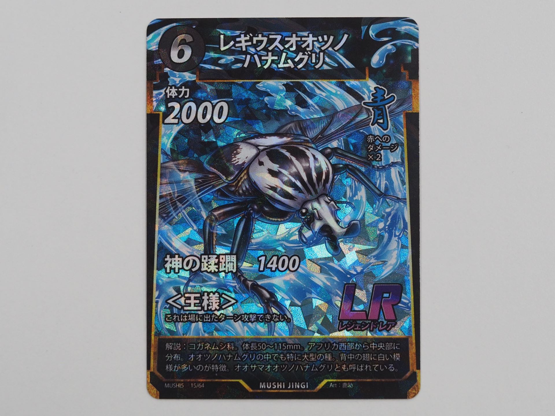 青6コストのLRカード「レギウスオオツノハナムグリ」。体力、攻撃力ともに大きいが、場に出たターンは攻撃できない＜王様＞というデメリット能力を持つ