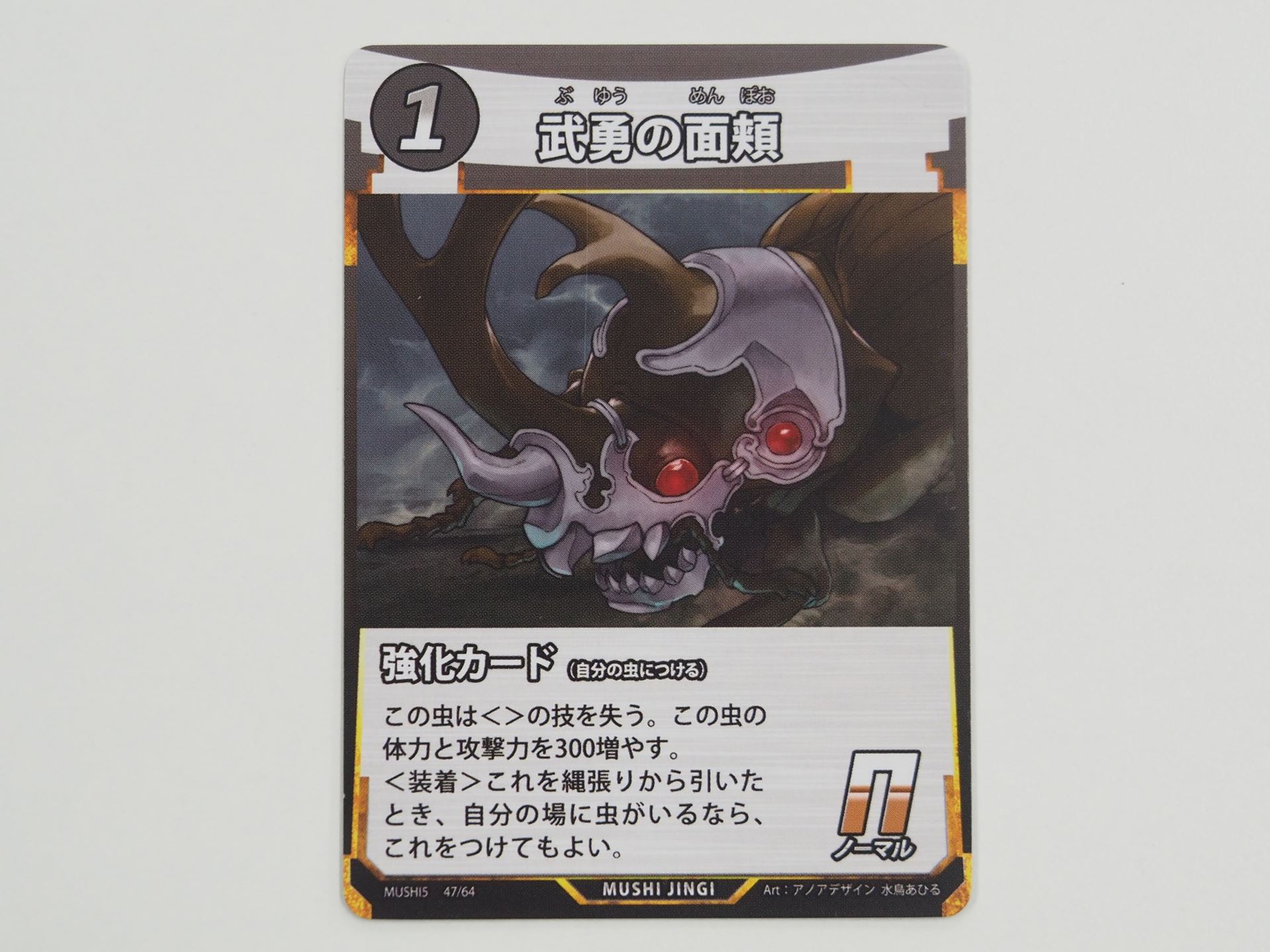 1コストのN強化カード「武勇の面頬」。先行体験会で初出のカード。付けることで、＜＞の技が失われるが、体力と攻撃力が300ずつ増える