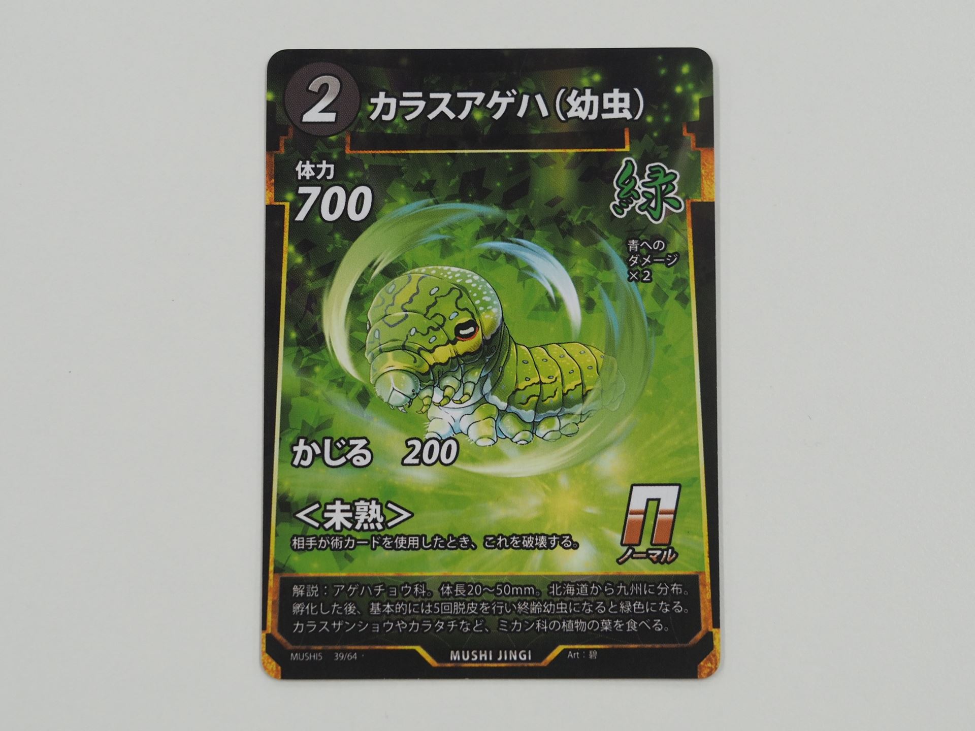 緑2コストのNカード「カラスアゲハ（幼虫）」。先行体験会で初出のカード。相手が術カードを使うと、破壊される＜未熟＞を持つ