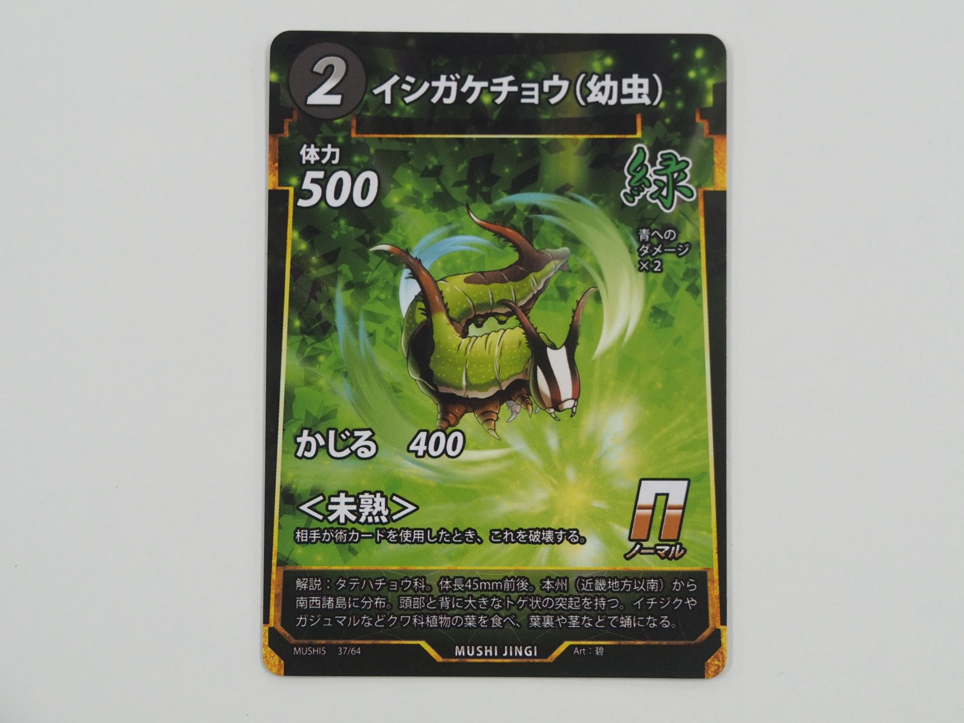 緑2コストのNカード「イシガケチョウ（幼虫）」。先行体験会で初出のカード。相手が術カードを使うと、破壊される＜未熟＞を持つ