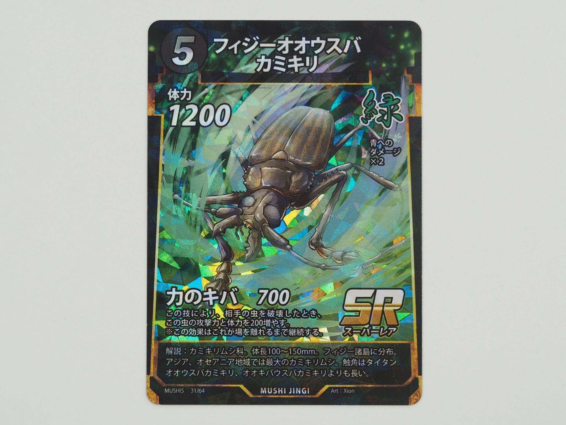 緑5コストのSRカード「フィジーオオウスバカミキリ」。先行体験会で初出のカード。相手の虫を破壊したときに、攻撃力と体力を200ずつ増やす「力のキバ」という技を持つ