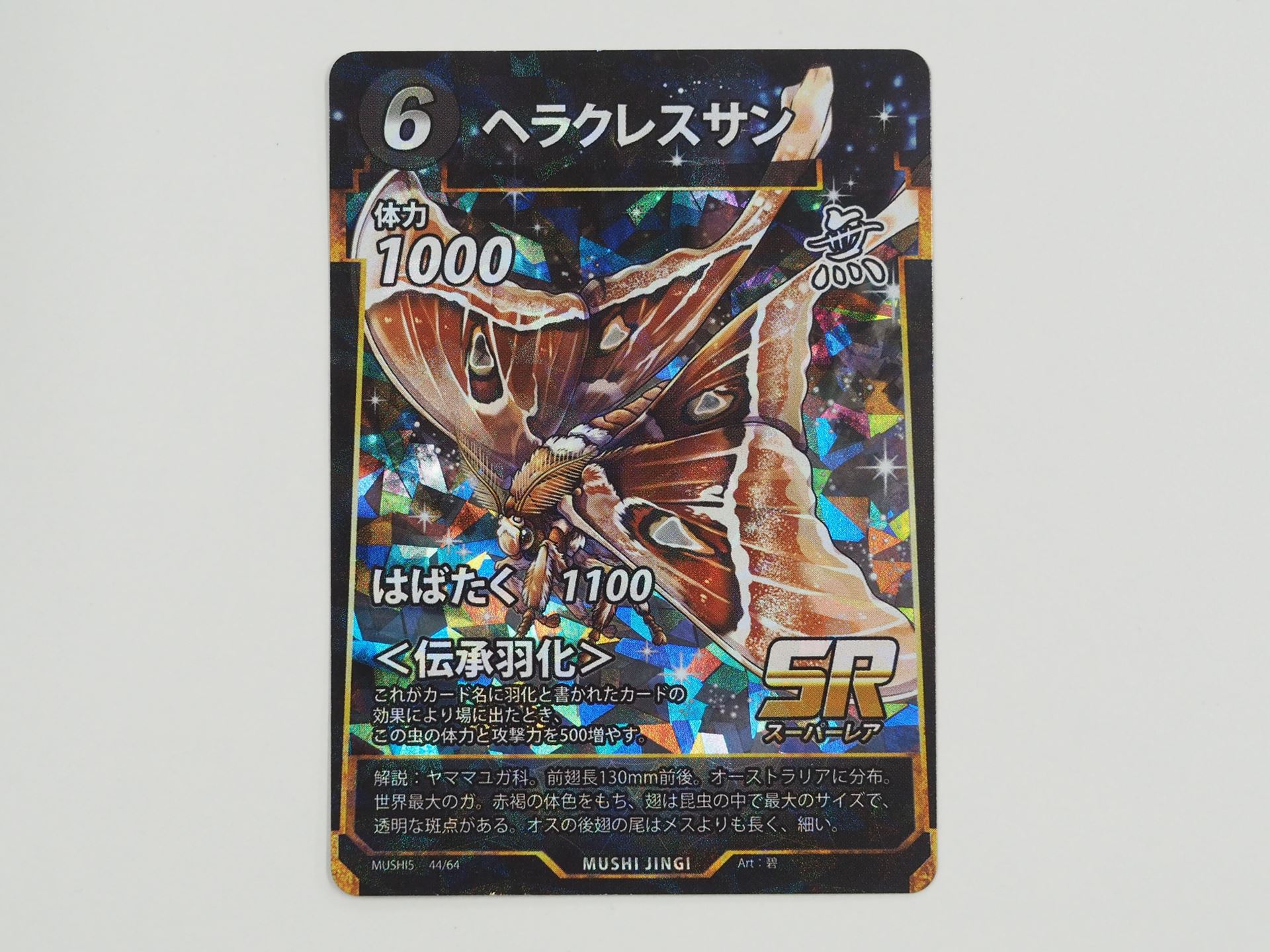 無色6コストのSR「ヘラクレスサン」。羽化と書かれたカードの効果で場に出たとき、体力と攻撃力を500ずつ増やす＜伝承羽化＞を持つ