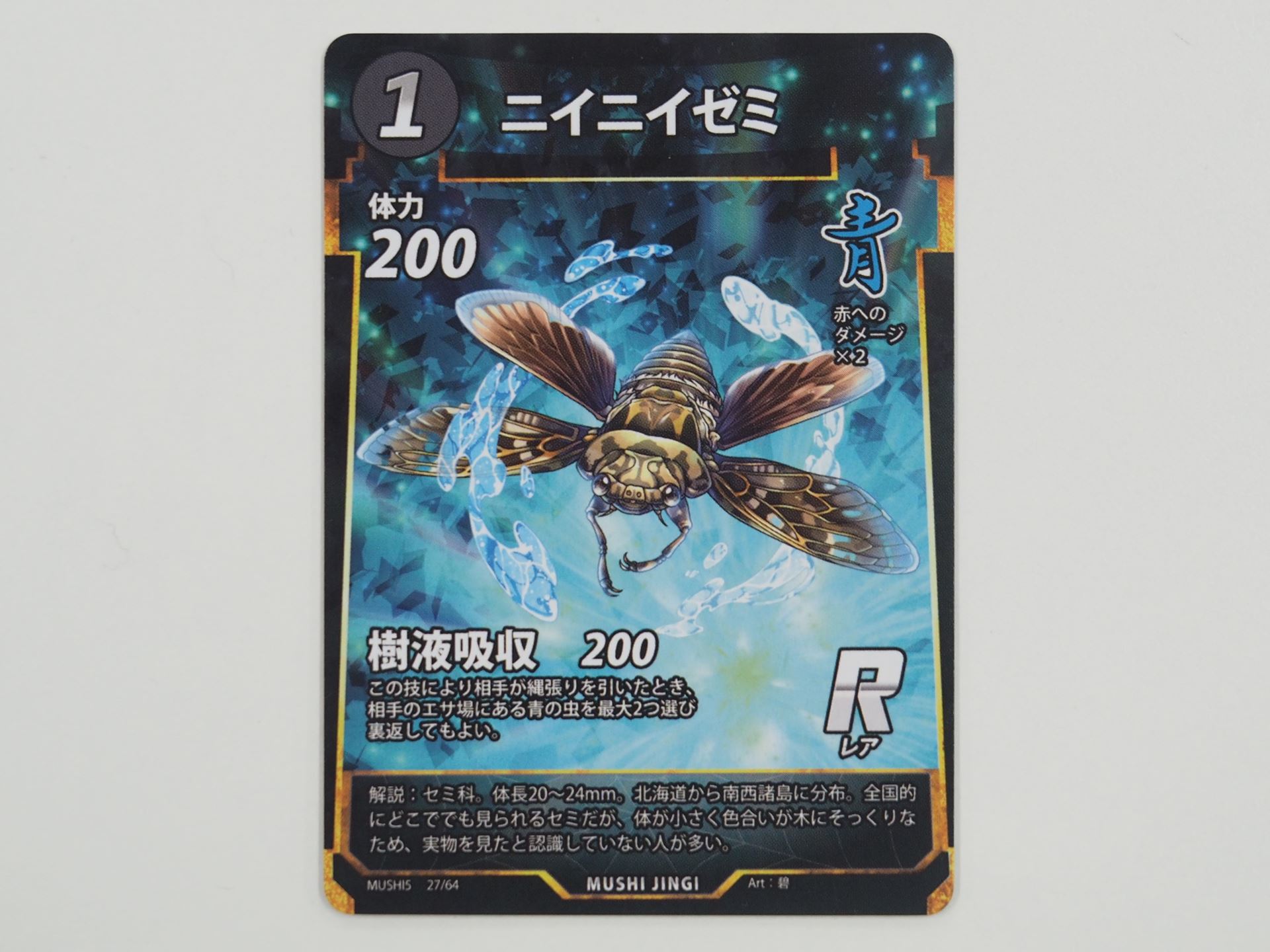 青1コストのRカード「ニイニイゼミ」。先行体験会で初出のカード。その技によって相手が縄張りを引いたとき、相手のエサ場にある青の虫を最大2つ選び裏返せる「樹液吸収」という技を持つ
