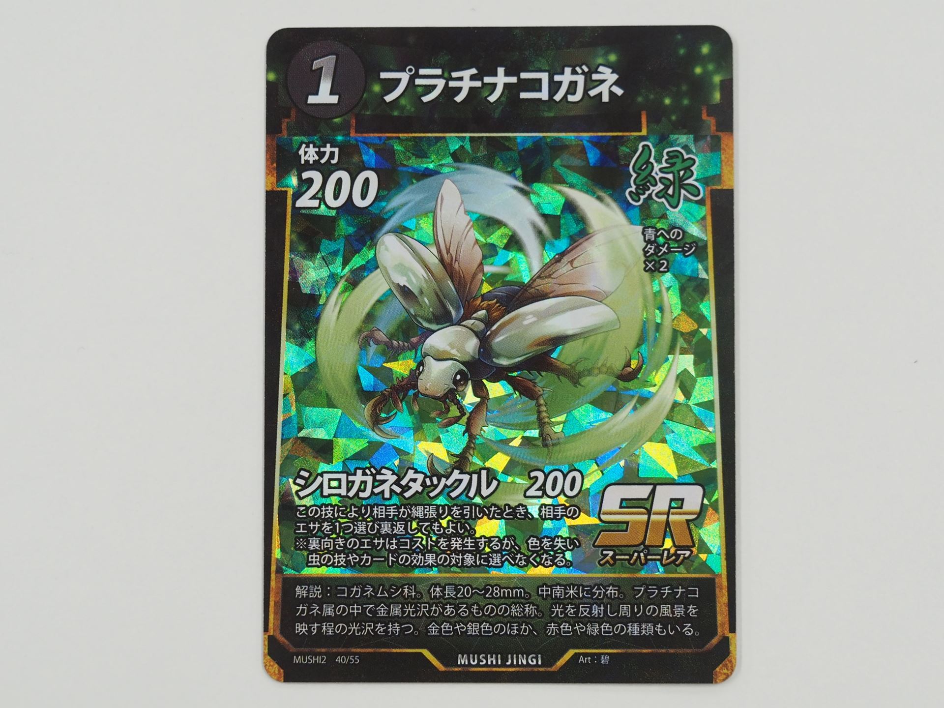 緑1コストのSRカード「プラチナコガネ」。その技によって相手が縄張りを引いたとき、相手のエサ場にあるカードを1つ選び裏返せる「シロガネタックル」という技を持つ