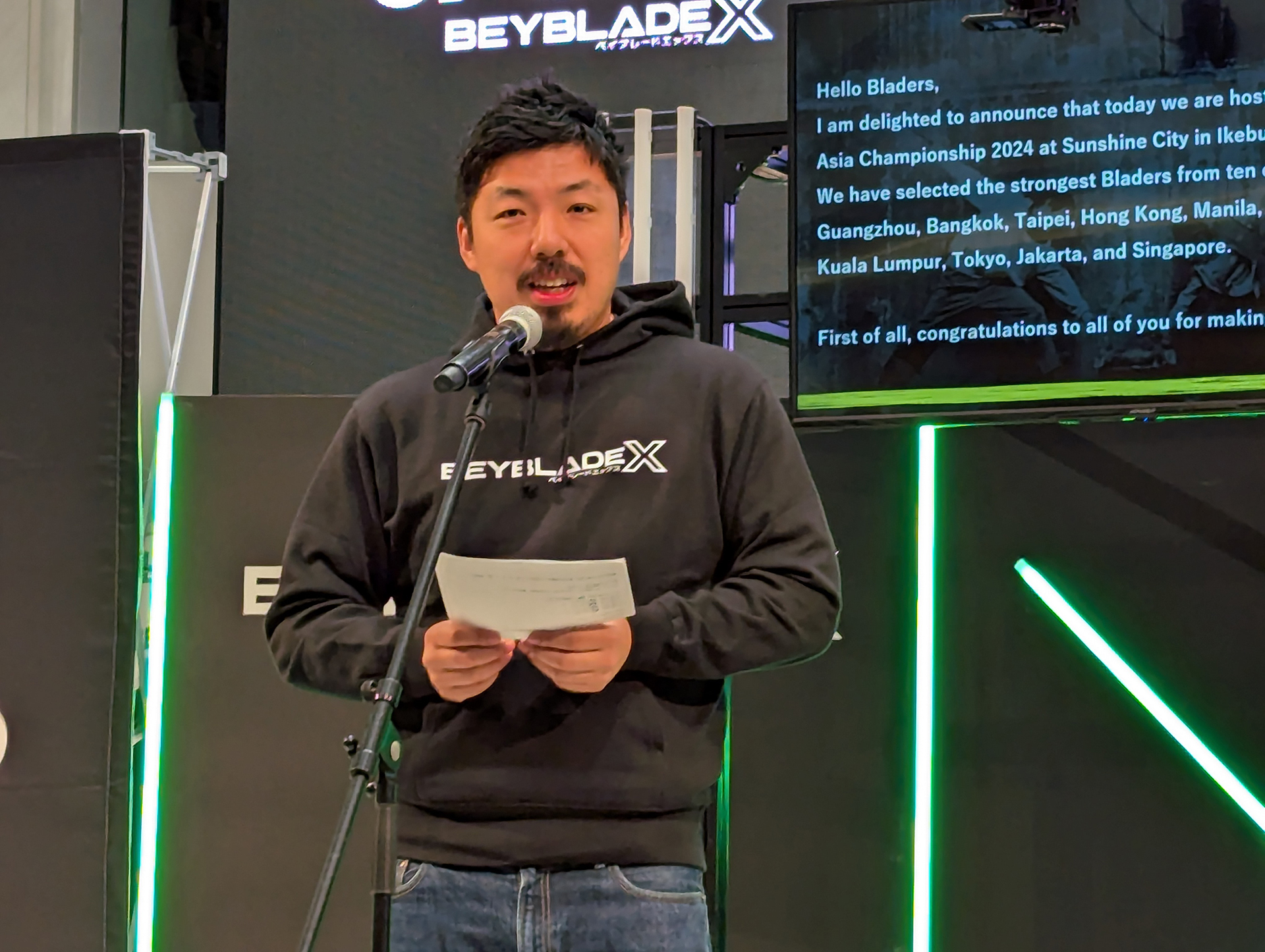 タカラトミー 代表取締役社長(COO)の富山彰夫氏より開会宣言が行なわれた。ディスプレイにはメッセージが英訳されて表示されており、他国からの観戦客たちへの配慮も見られた