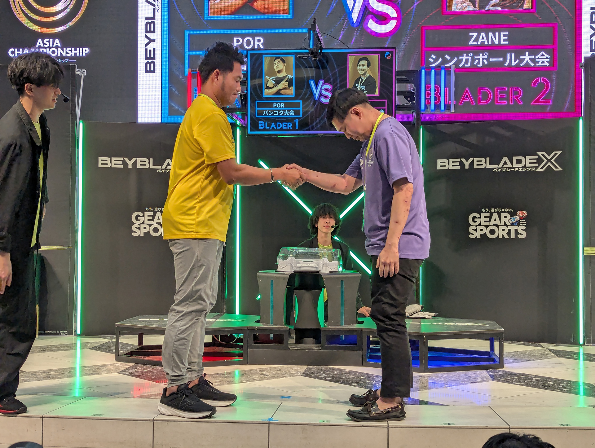 2回戦シンガポール代表ZANEとバンコク代表PORの一戦より。開始前の握手は大人も子供も関係なく行なわれる