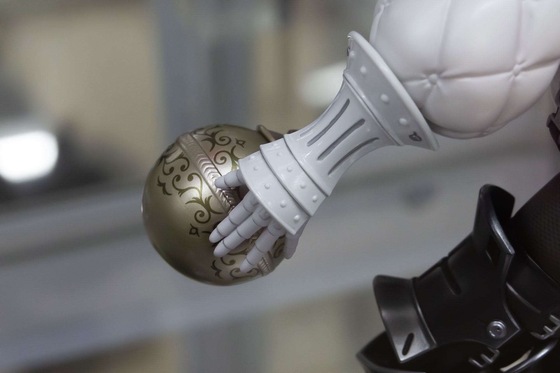 先端が丸みをおびたアンティークなデザインの杖を手に持っている