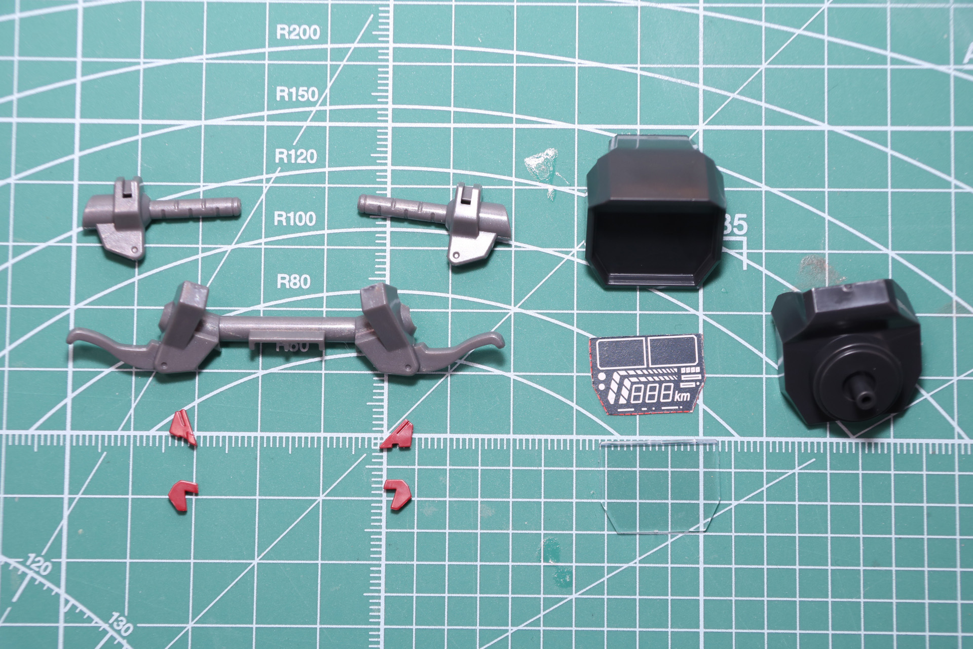 ハンドル組み立て。グリップやバーの造形はもちろん、手元で操作できるスイッチも成型色で色分けされている。中央のデジタルメーターは取扱説明書からイラストを切り離して挟み込む