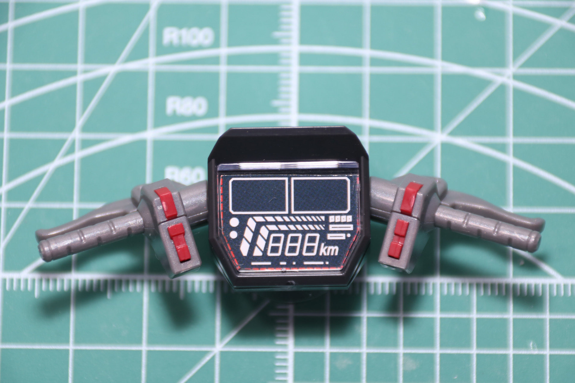 ハンドル組み立て。グリップやバーの造形はもちろん、手元で操作できるスイッチも成型色で色分けされている。中央のデジタルメーターは取扱説明書からイラストを切り離して挟み込む